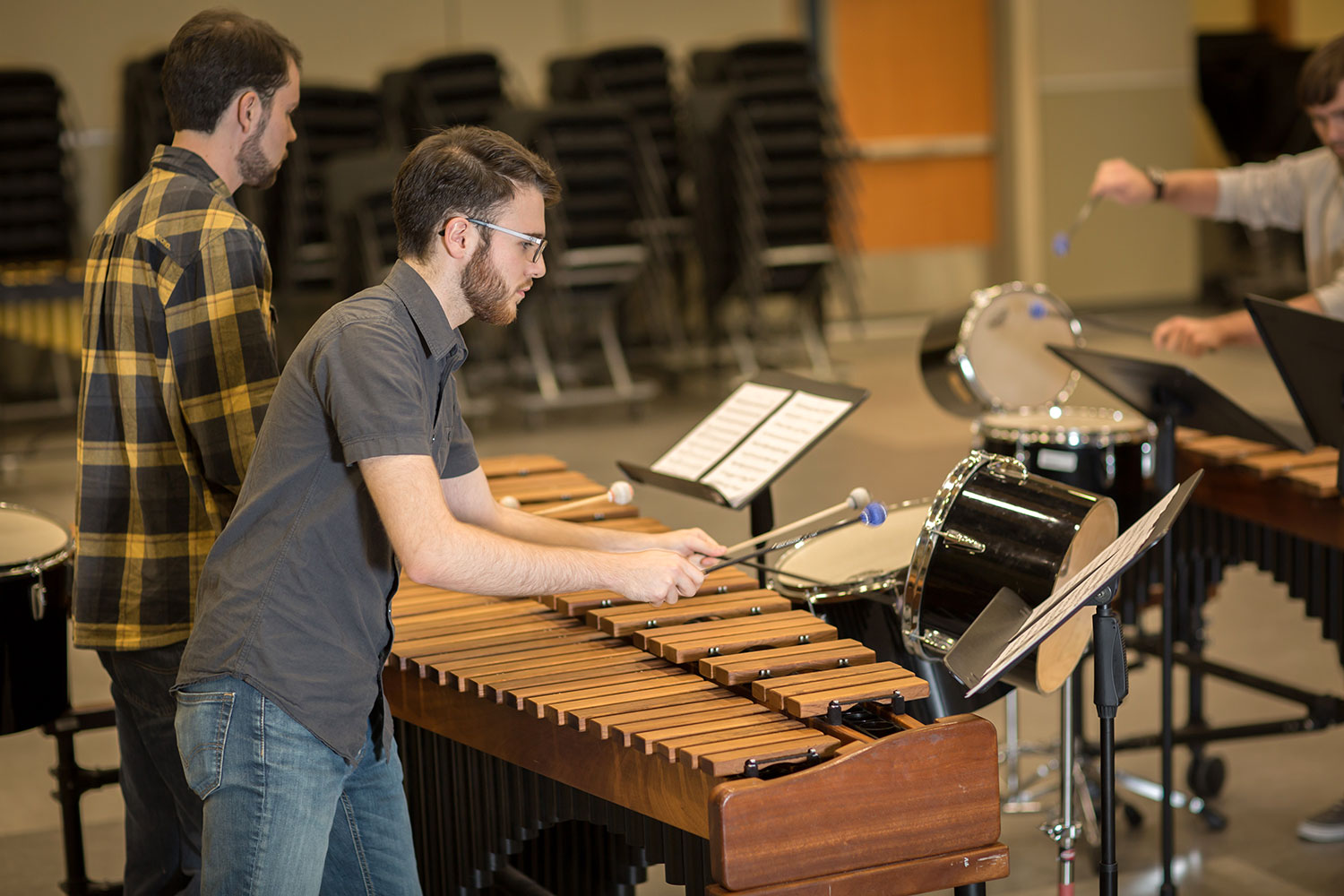Percussion students playing instruments in rehearsal room