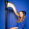 photo of Taylor Fleshman with her harp against blue background