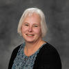 Professor Elizabeth Hornsby-Graham wearing blue shirt on grey background